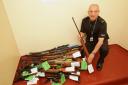 Firearms officer James Young with some of the weapons handed in